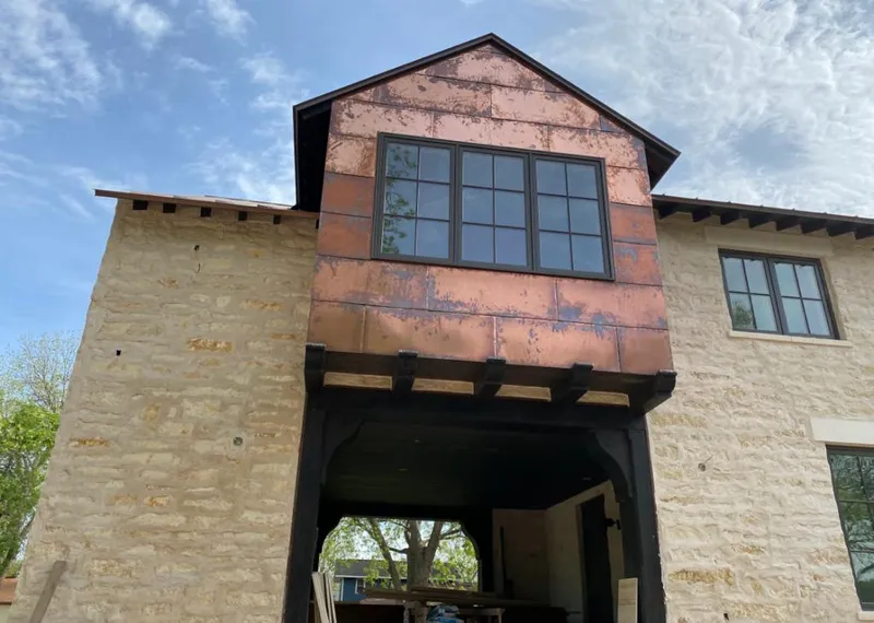 Copper metal panel facade on a stone building for Roof Repair in Corrales