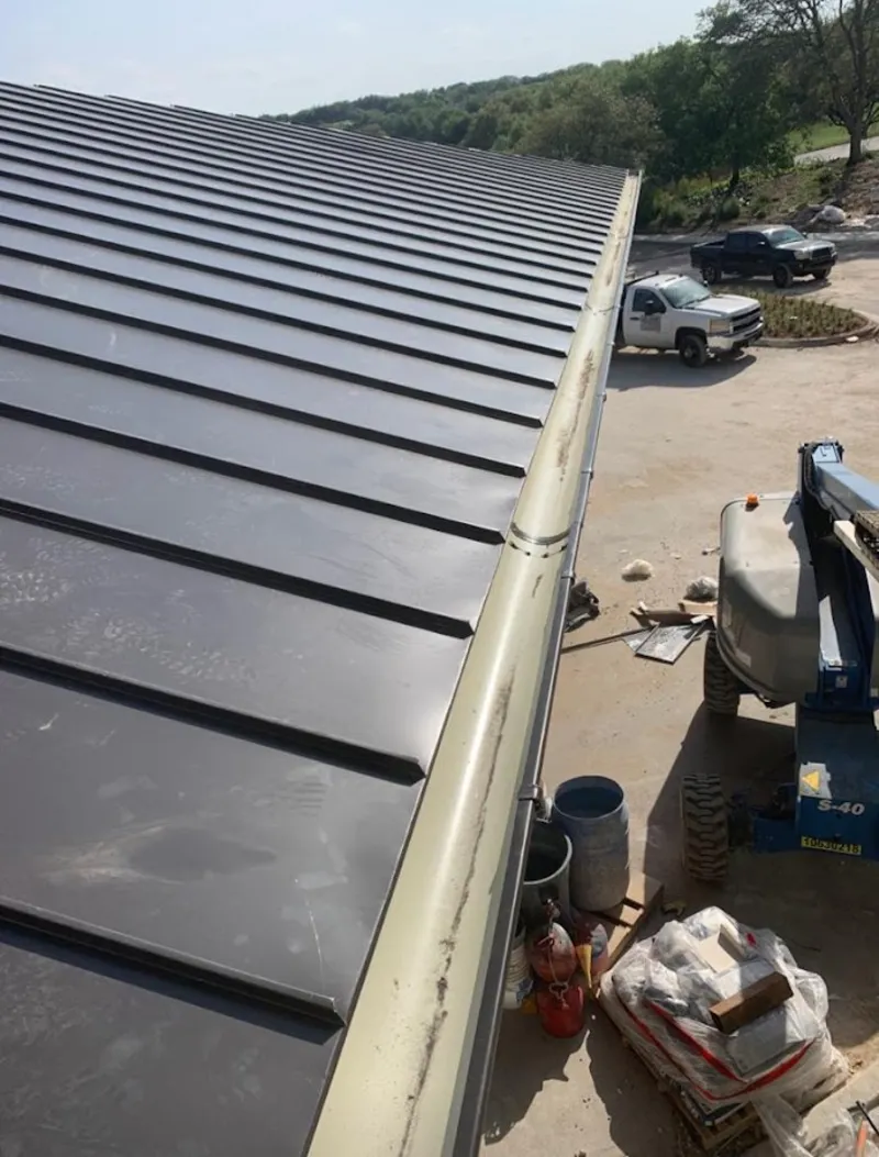 Standing seam panel and gutter detail on a metal roofing jobsite in Corrales